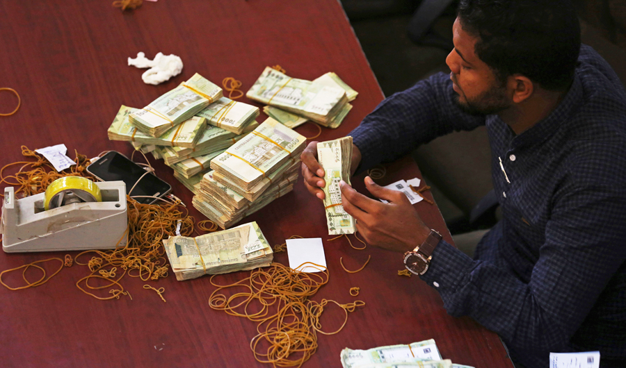A worker counts money in Yemen’s Central Bank in Aden. (AP)