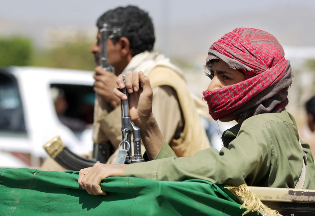 An armed supporter of Houthis sits in the back of a pick up. (File/AFP)