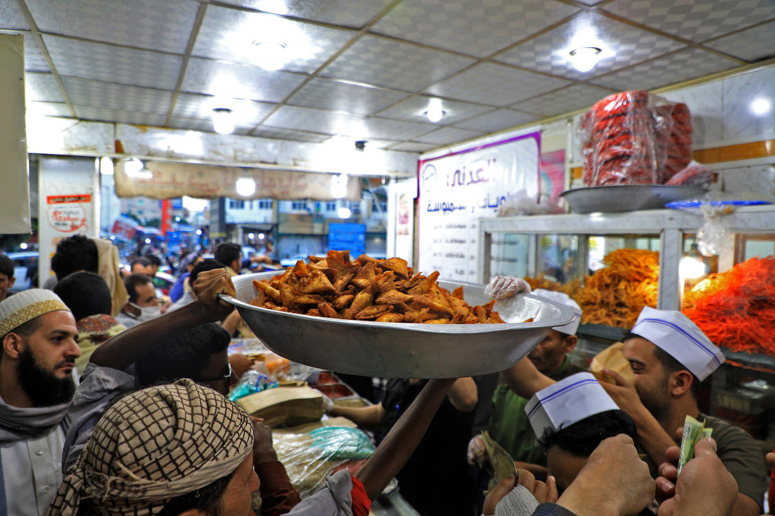 Yemenis queue up in a shop selling “sambusa” in Sanaa late on April 19, 2021 during the Muslim holy month of Ramadan in which practicing Muslims fast from dawn to dusk and eat only after sunset. (File/AFP) Yemenis queue up in a shop selling “sambusa” in Sanaa late on April 19, 2021 during the Muslim holy month of Ramadan in which practicing Muslims fast from dawn to dusk and eat only after sunset. (File/AFP)